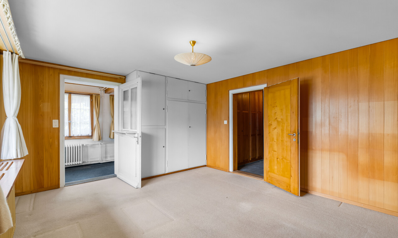 spare room featuring wooden walls, light colored carpet, and radiator