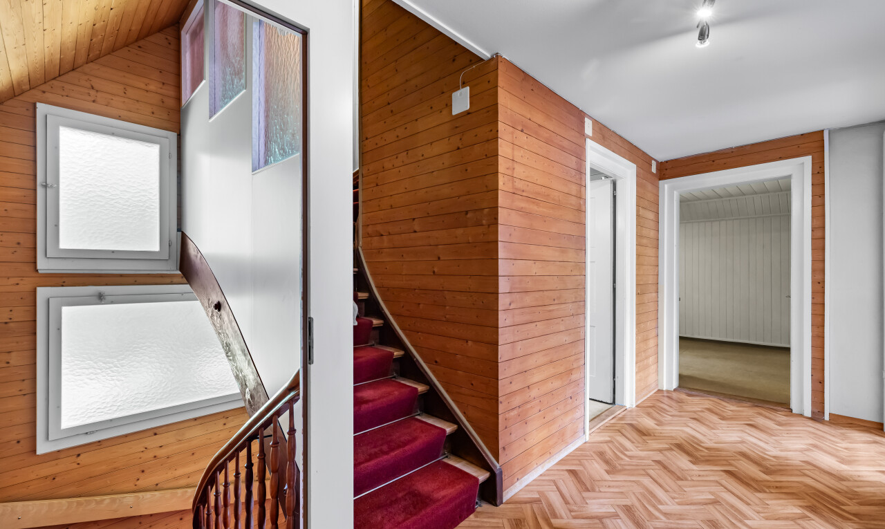 stairway with wood walls and parquet flooring