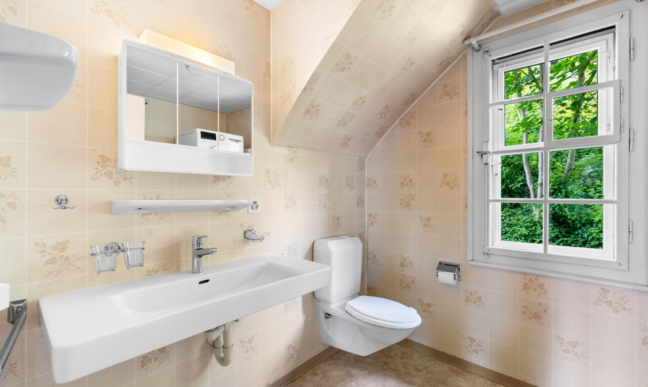 bathroom featuring tile walls and vaulted ceiling