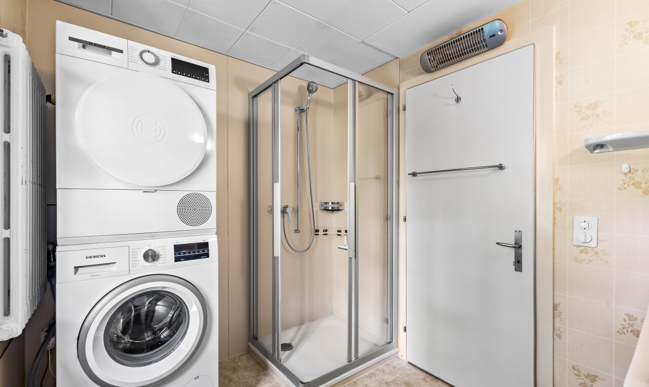 full bathroom with a stall shower and stacked washer and dryer