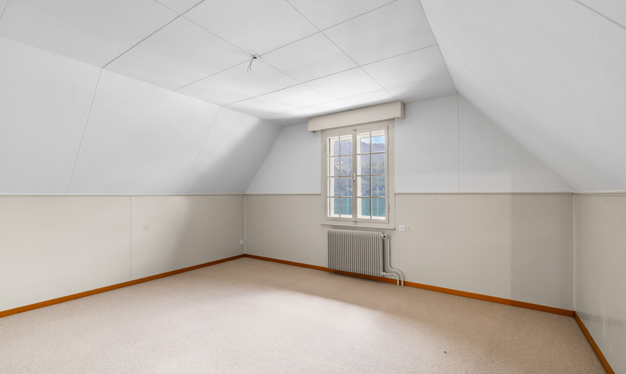 carpeted empty room with radiator heating unit and baseboards
