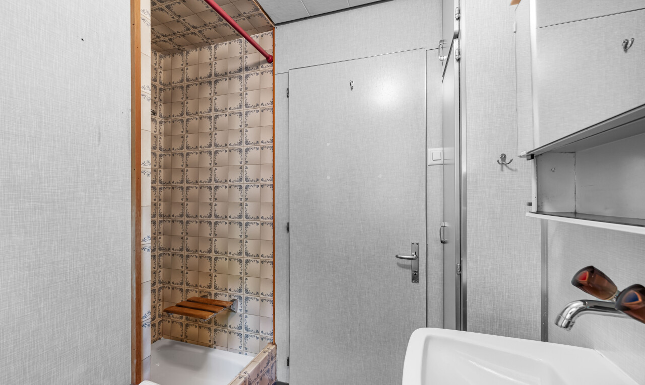 bathroom featuring a stall shower and a sink