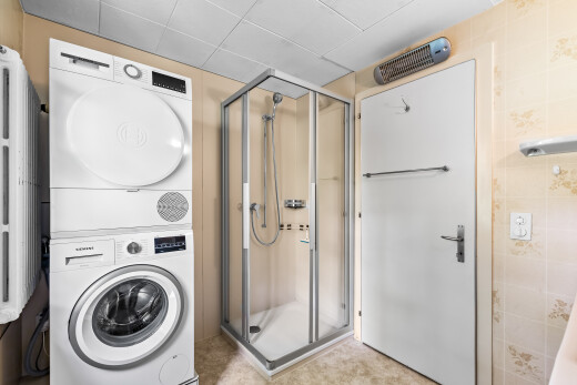 salle de bains avec douche, lave-linge et sèche-linge superposés, inside property, salle de bain complète, et light floor