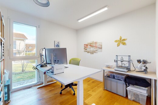 büro mit fernseher, natürliches licht, bürobereich, und holzfußboden