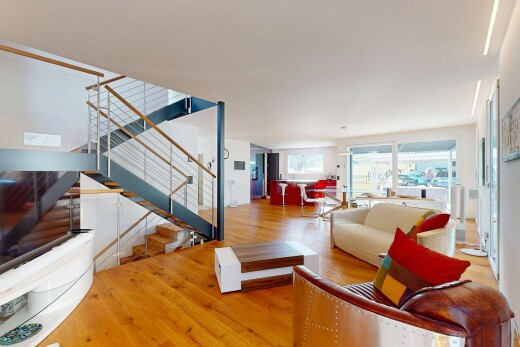 wohnzimmer mit holzfußboden, natürliches licht, gipskartonwand, und treppen