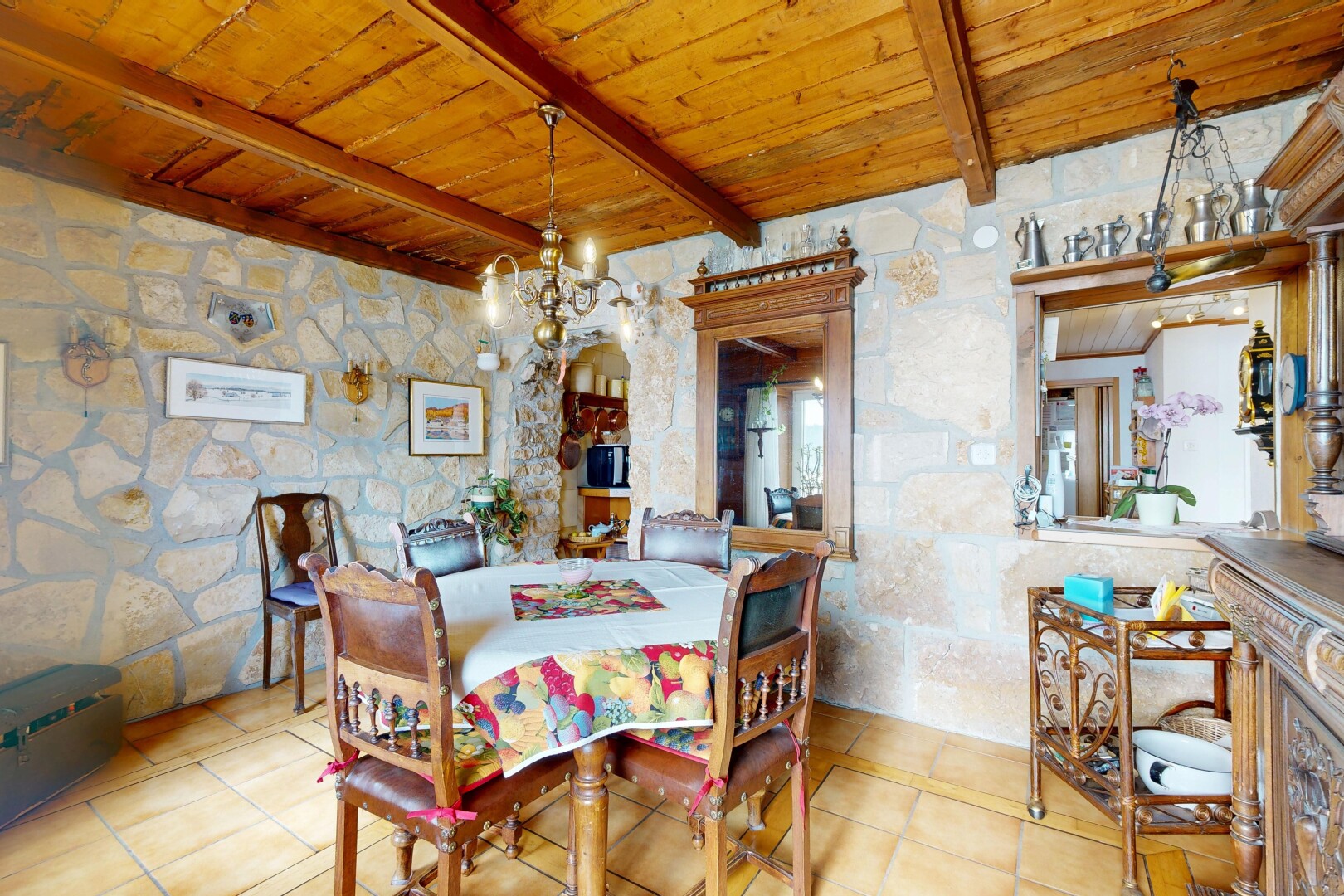 salle à manger avec stone wall, mur en pierre, wood ceiling, plafond en bois, et inside property