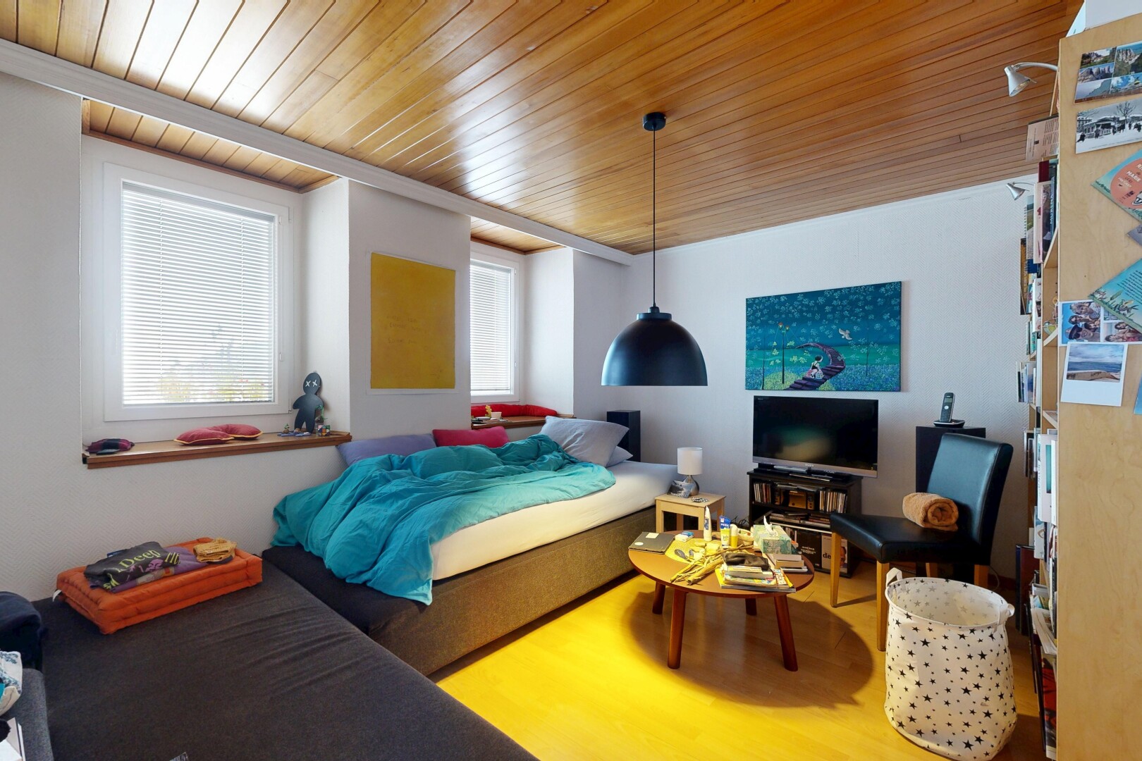 chambre avec inside property, télévision, cloison sèche, drywall, et sol en finition bois
