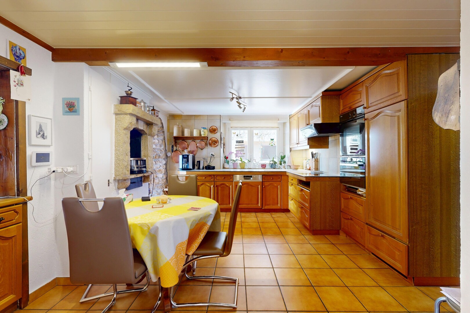 cuisine avec armoires en arc, armoires marron moyen, inside property, tile floor, et sol en carrelage
