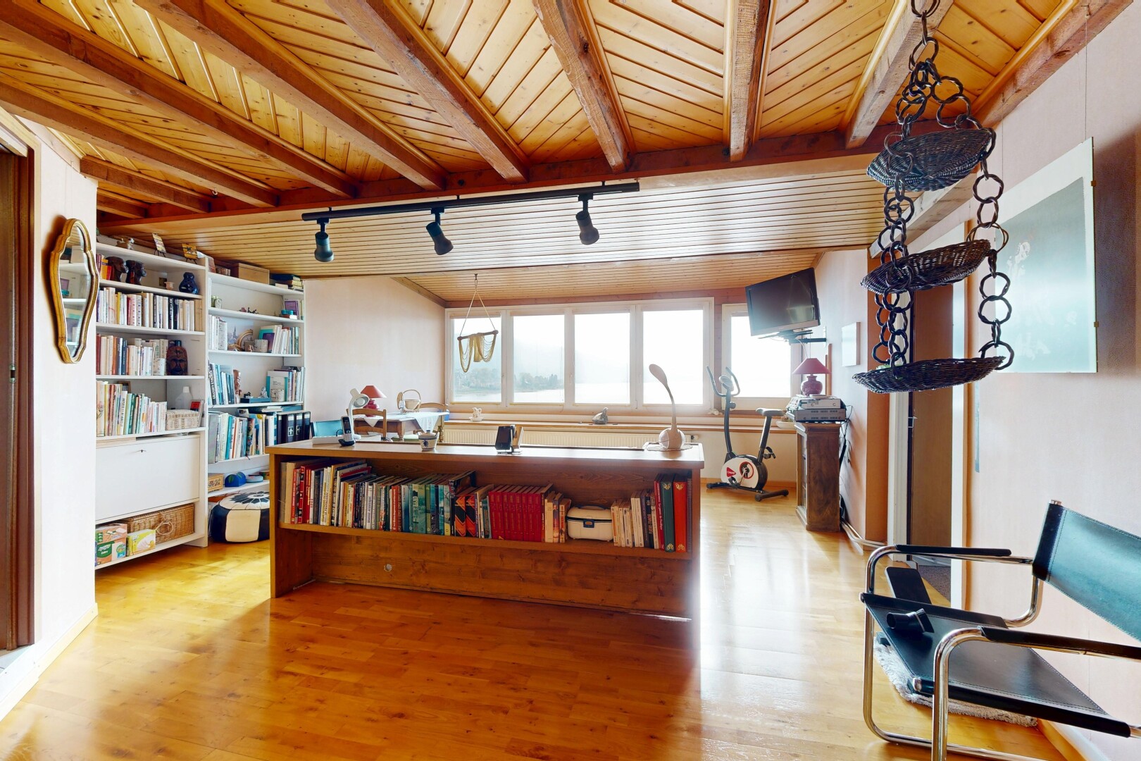 salon avec track lighting, éclairage sur rail, natural light, beamed ceiling, et lumière naturelle