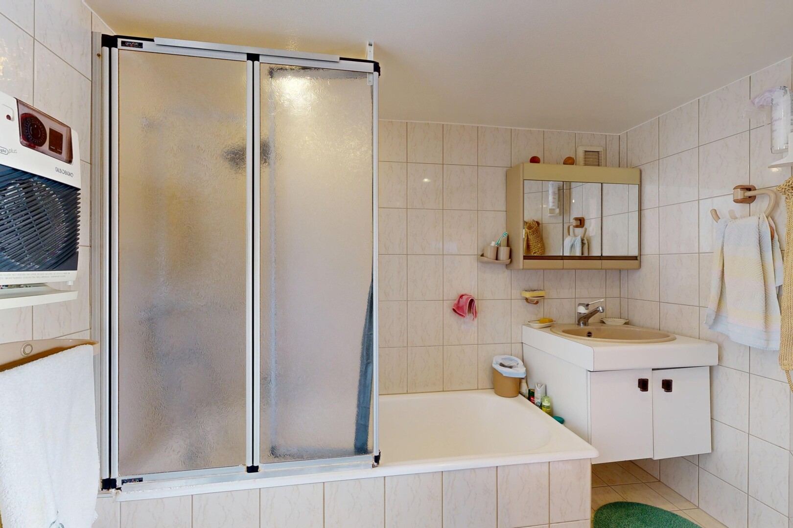 salle de bains avec tile wall, mur en carrelage, lavabo (ou coiffeuse selon le contexte), miroir, et inside property