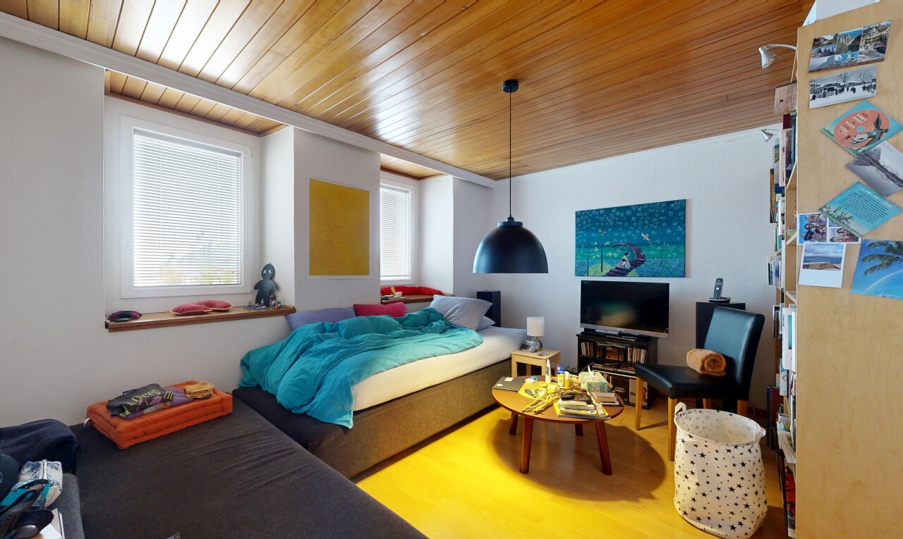 chambre avec inside property, télévision, cloison sèche, drywall, et sol en finition bois