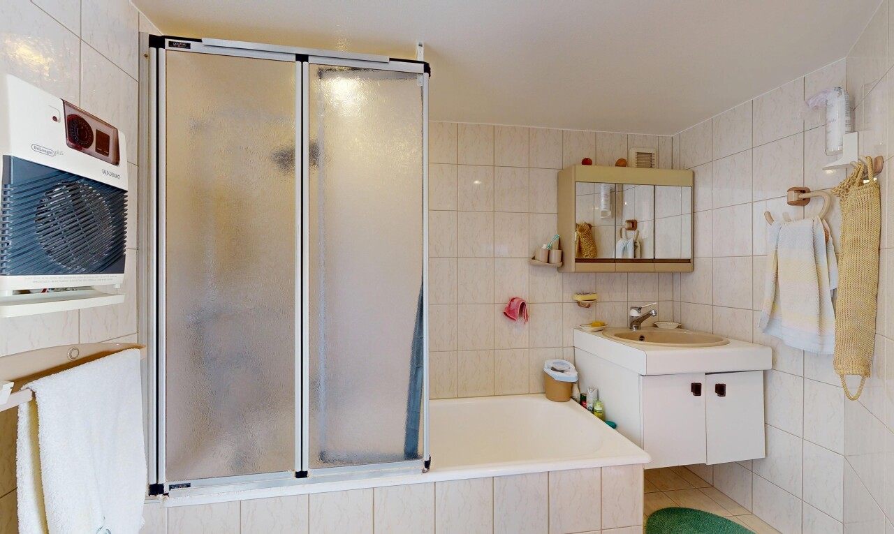 salle de bains avec tile wall, mur en carrelage, lavabo (ou coiffeuse selon le contexte), miroir, et inside property