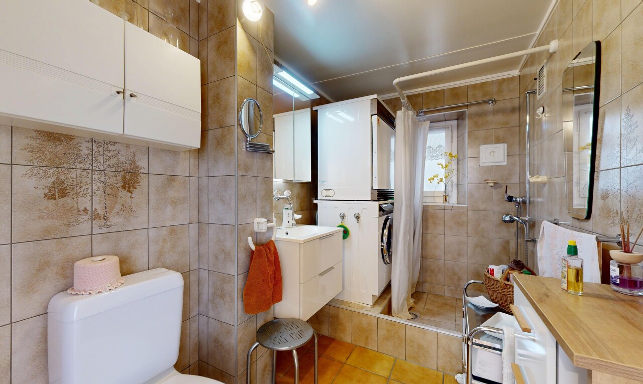 salle de bains avec mur en carrelage, tile wall, lavabo (ou coiffeuse selon le contexte), salle de bain complète, et douche