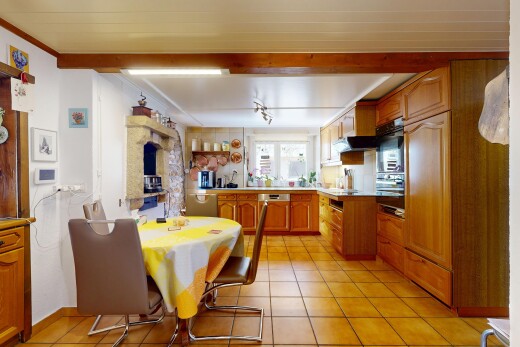 cuisine avec armoires en arc, armoires marron moyen, inside property, tile floor, et sol en carrelage