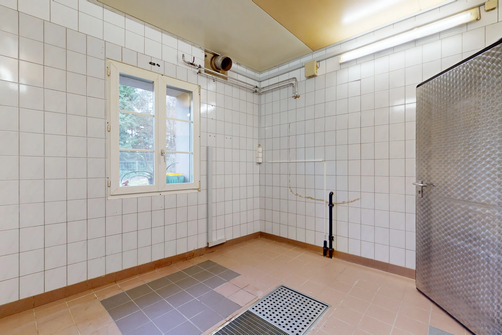 unfurnished room featuring light tile floors and tile walls