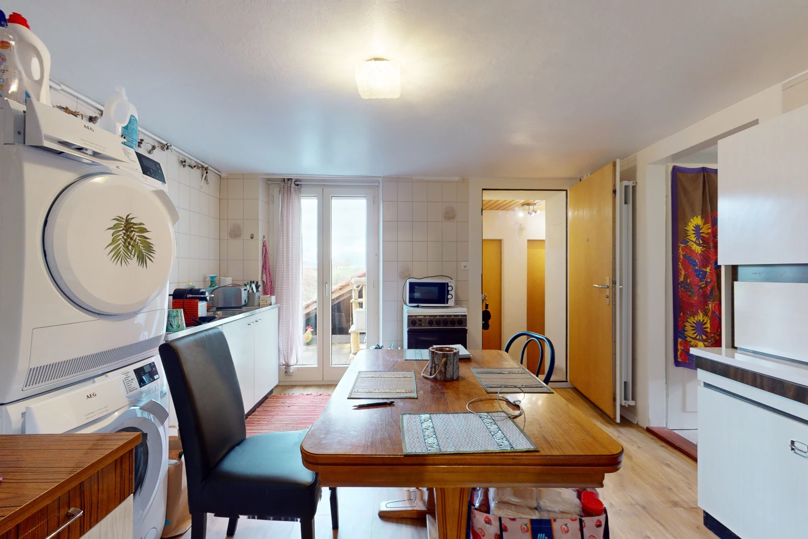 dining room with stacked washer and clothes dryer, tile walls, light hardwood / wood-style flooring, and french doors