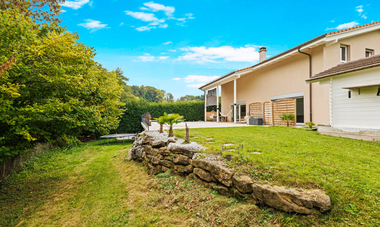 façade avec property visible, bardage en stuc, pelouse, cheminée, et day time