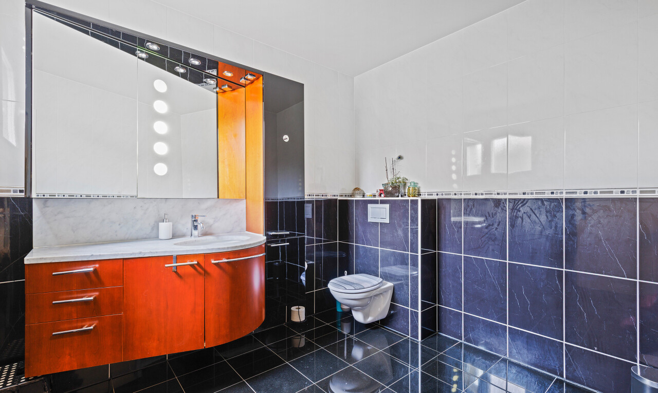 bathroom featuring tile walls, vanity, and dark tile patterned flooring