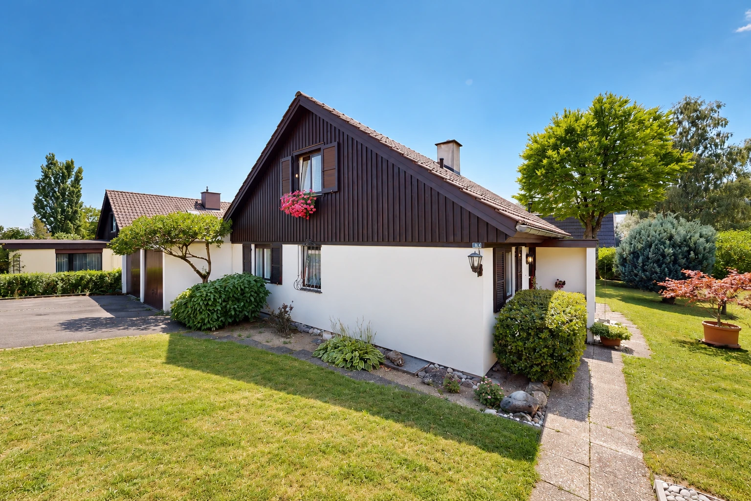 außenansicht mit property visible, auffahrt, stuckverkleidung, rasen, und garage angeschlossen