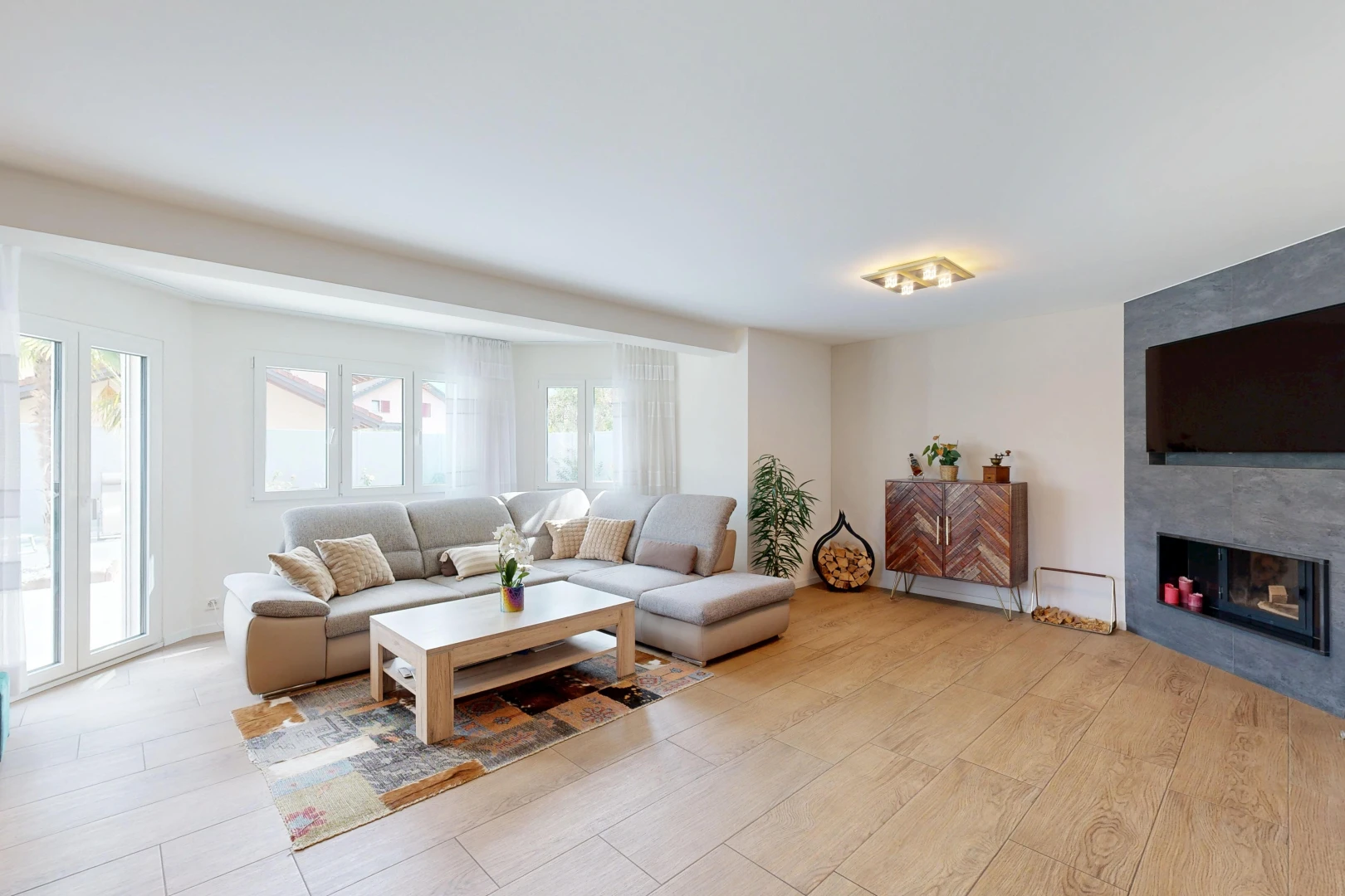 salon avec cheminée, cloison sèche, drywall, light floor, et télévision