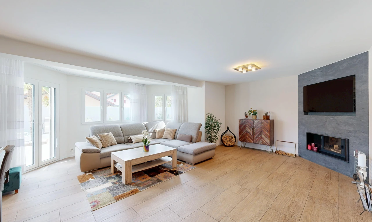 salon avec cheminée, cloison sèche, drywall, light floor, et télévision