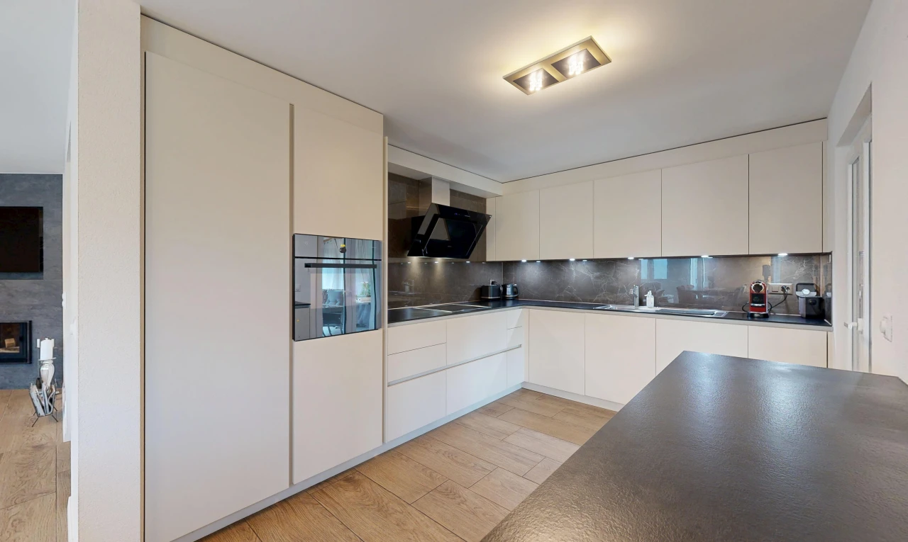 cuisine avec hotte, plans de travail, dark countertops, four, et light floor