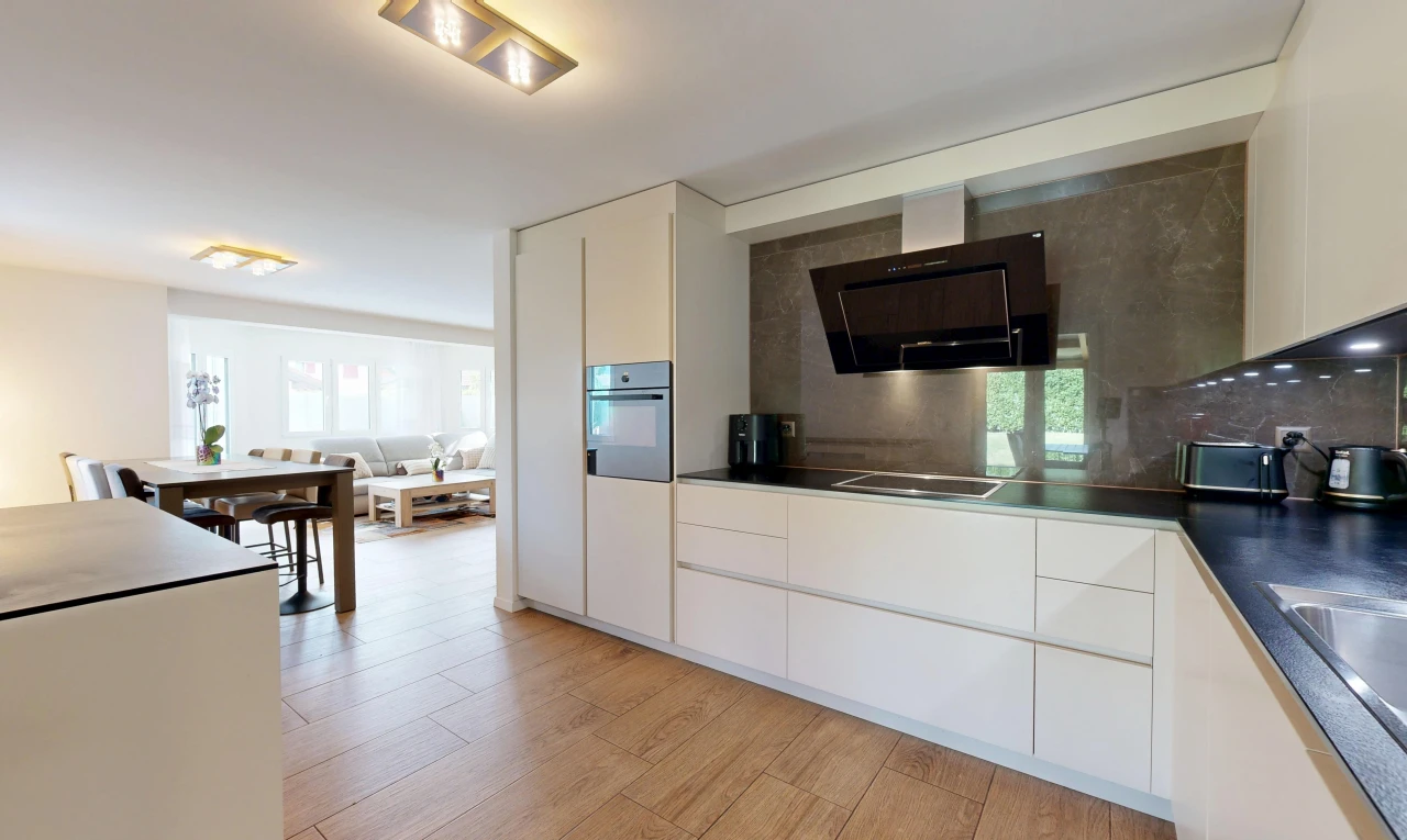 cuisine avec hotte, dark countertops, plans de travail, white cabinets, et armoires blanches