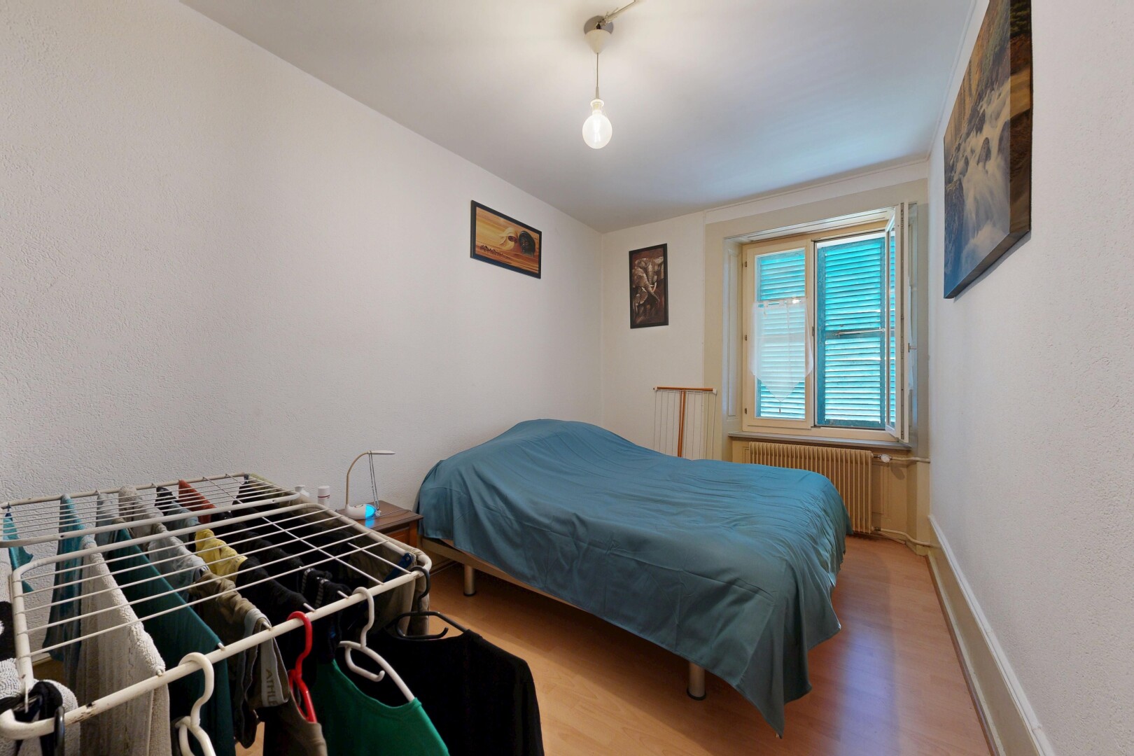 chambre avec sol en finition bois, wood finish floor, radiateur, inside property, et lumière naturelle