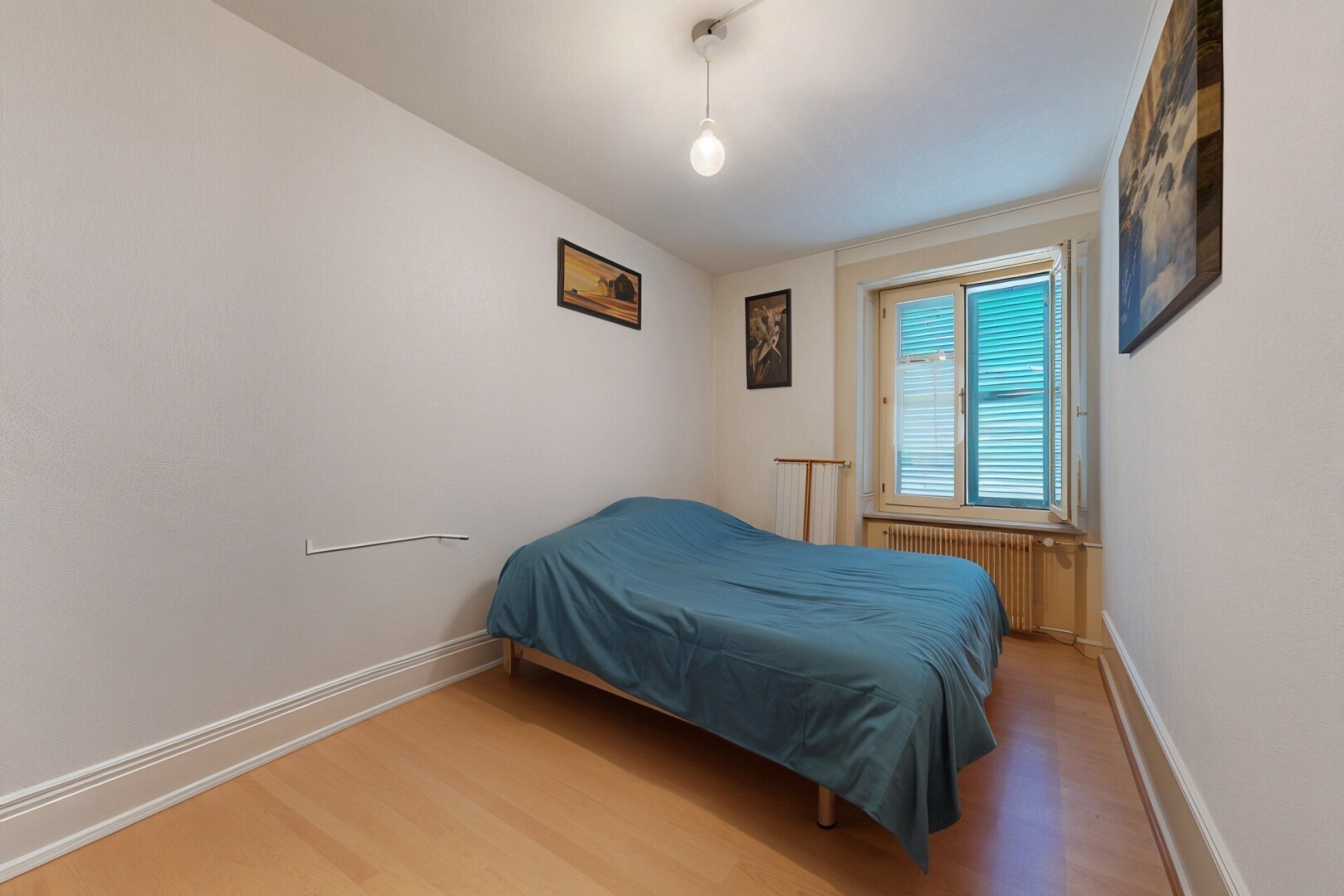 chambre avec sol en finition bois, wood finish floor, radiateur, inside property, et lumière naturelle