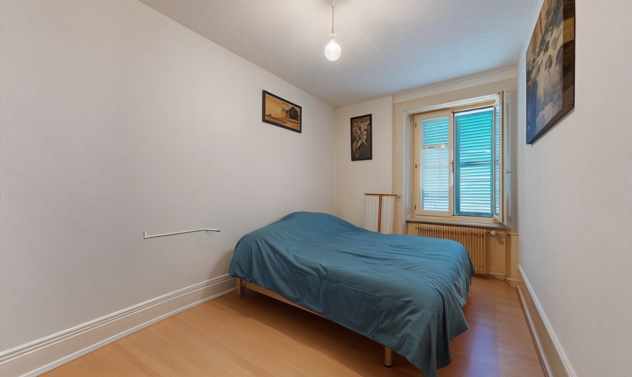 chambre avec sol en finition bois, wood finish floor, radiateur, inside property, et lumière naturelle