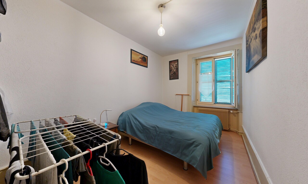 chambre avec sol en finition bois, wood finish floor, radiateur, inside property, et lumière naturelle