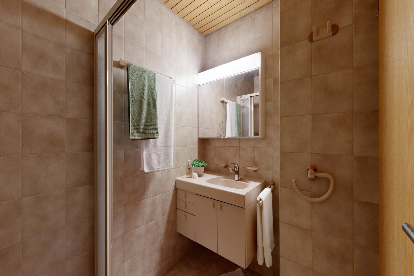 full bathroom featuring vanity and tile walls