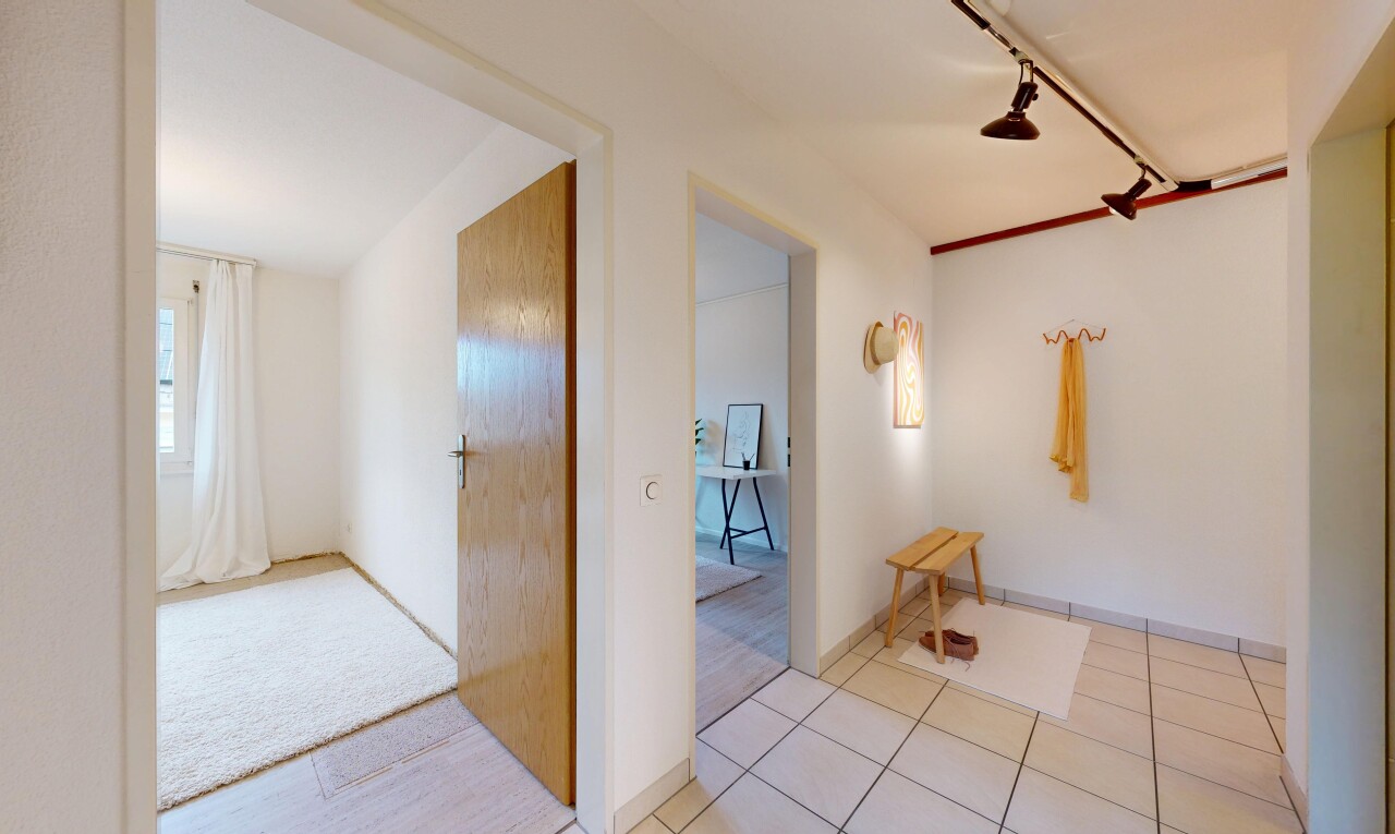 corridor featuring track lighting and light tile patterned floors