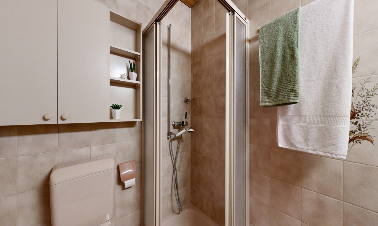 bathroom featuring a stall shower and tile walls