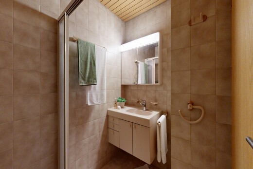 salle de bains avec miroir, lavabo (ou coiffeuse selon le contexte), inside property, mur en carrelage, et tile wall