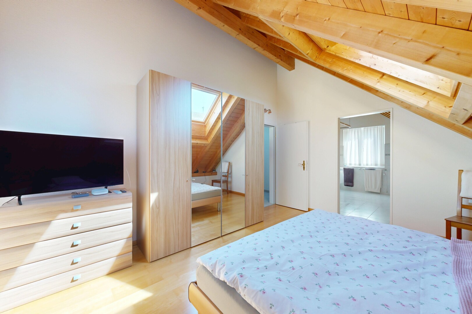 chambre avec puits de lumière, télévision, beamed ceiling, plafond à poutres, et inside property