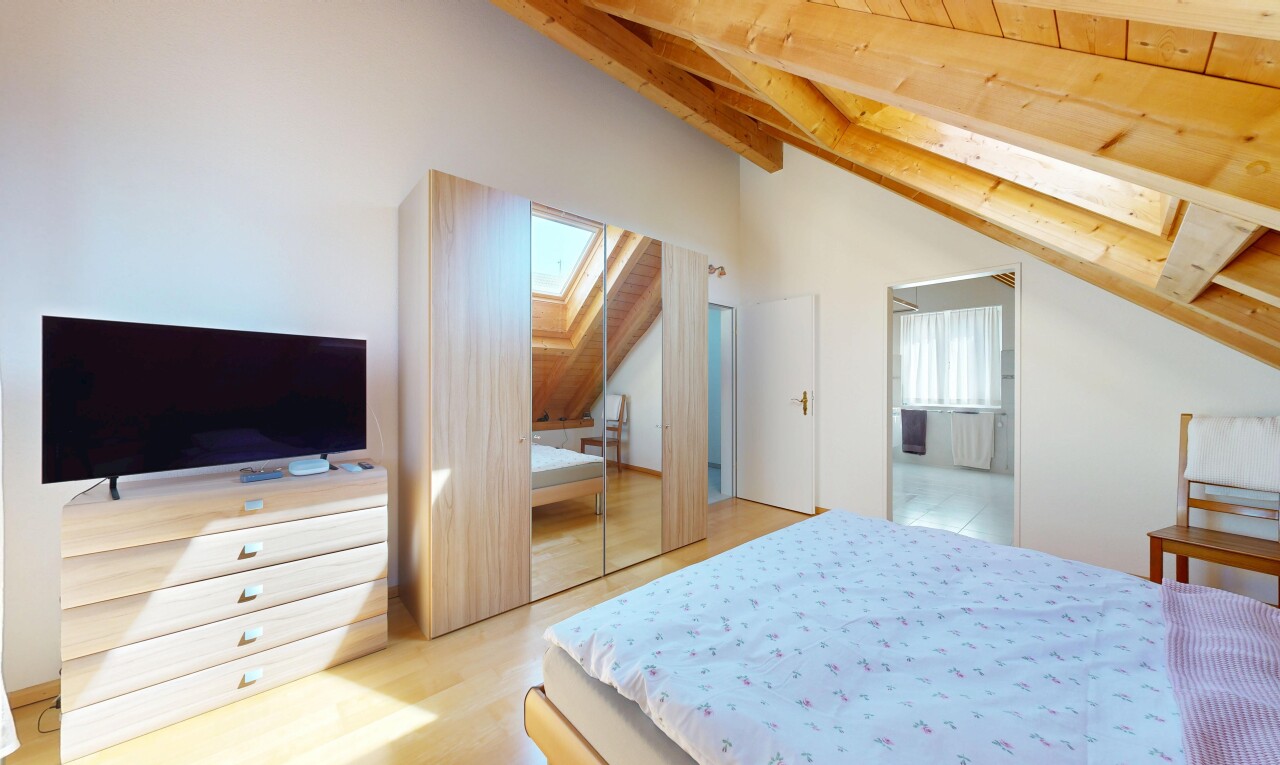 chambre avec puits de lumière, télévision, beamed ceiling, plafond à poutres, et inside property