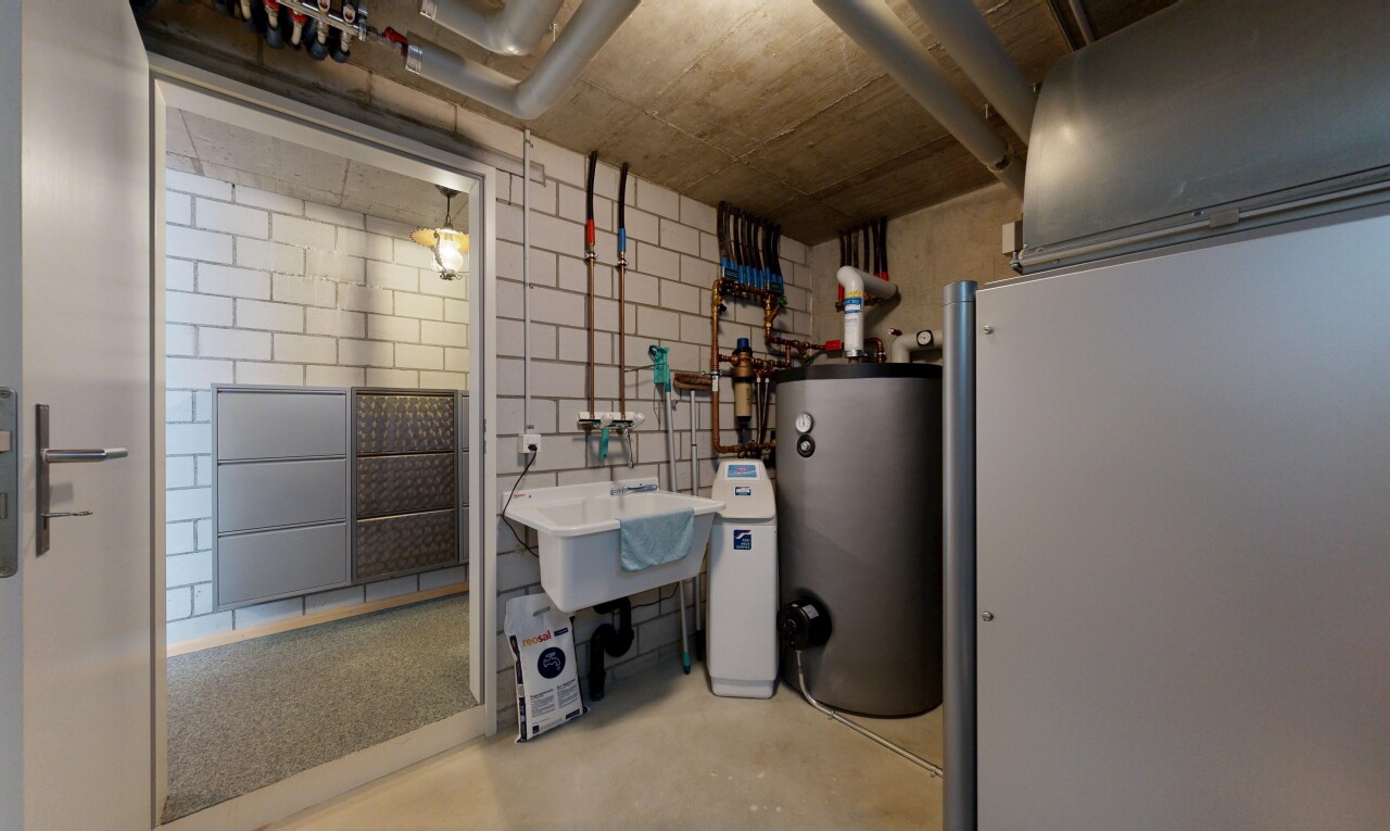 cuisine avec inside community, chauffe-eau, light floor, concrete floor, et évier