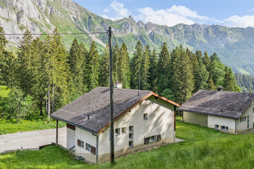 außenansicht mit stuckverkleidung, blick auf die berge, mountain view, rasen, und property visible