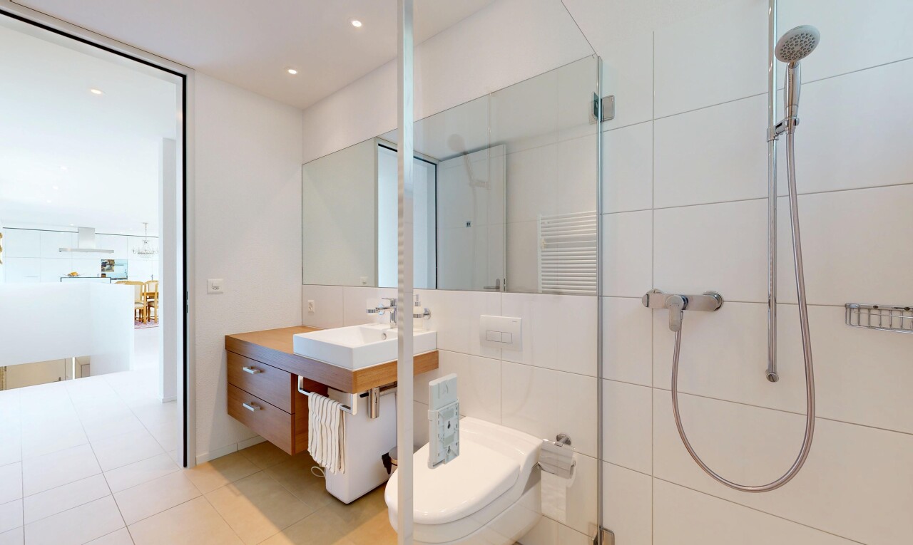 full bath featuring a stall shower, vanity, radiator, a towel warming rack, and tile walls