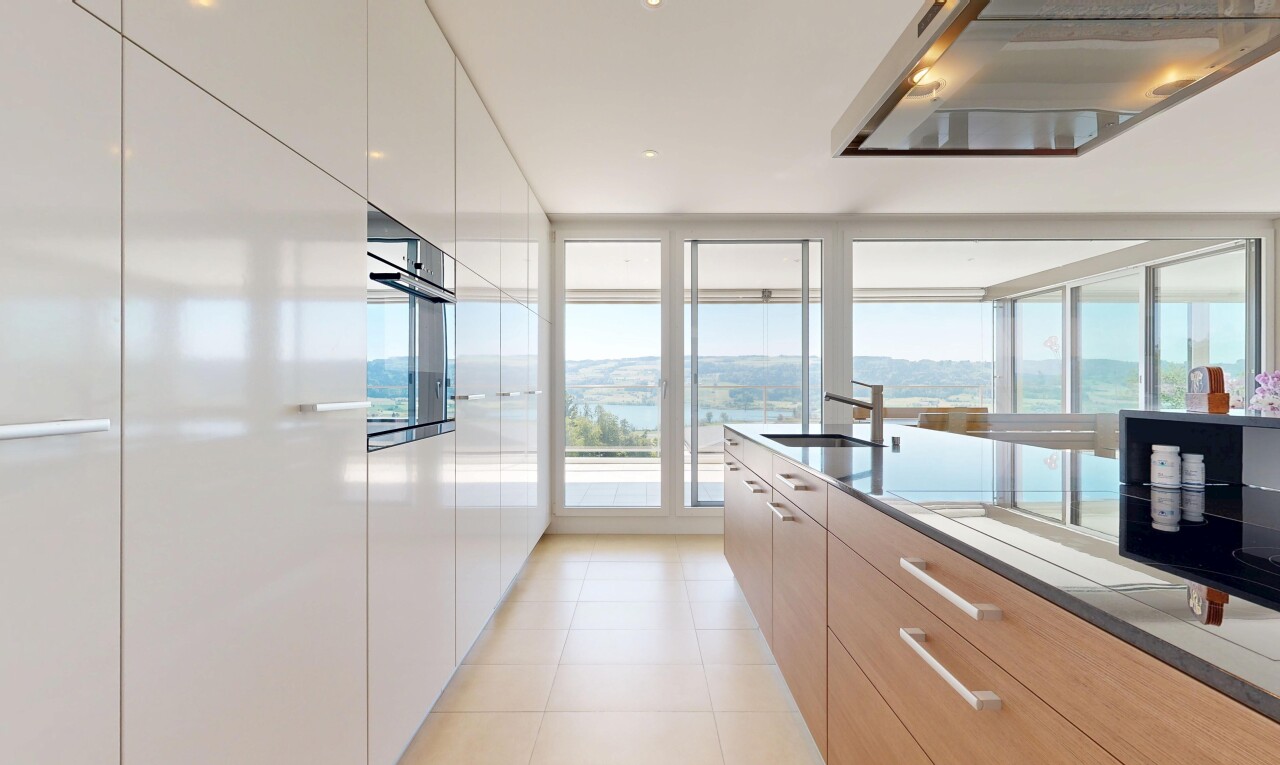 kitchen featuring ventilation hood, modern cabinets, oven, light tile patterned floors, and expansive windows