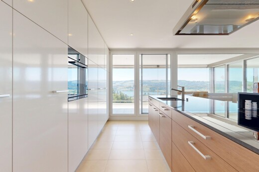 kitchen featuring ventilation hood, modern cabinets, oven, light tile patterned floors, and expansive windows