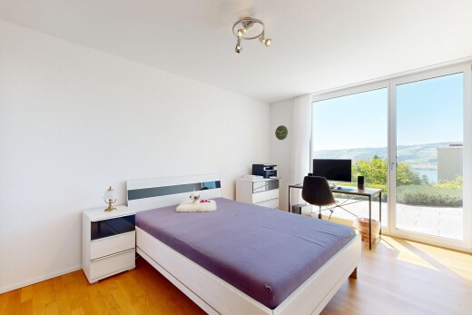 room / bedroom featuring light wood finished floors, an office area, access to outside, and expansive windows