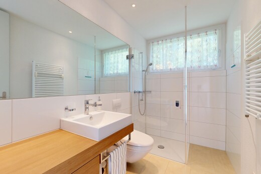 salle de bains avec chauffe-serviettes, salle de bain complète, radiateur, lavabo (ou coiffeuse selon le contexte), et douche