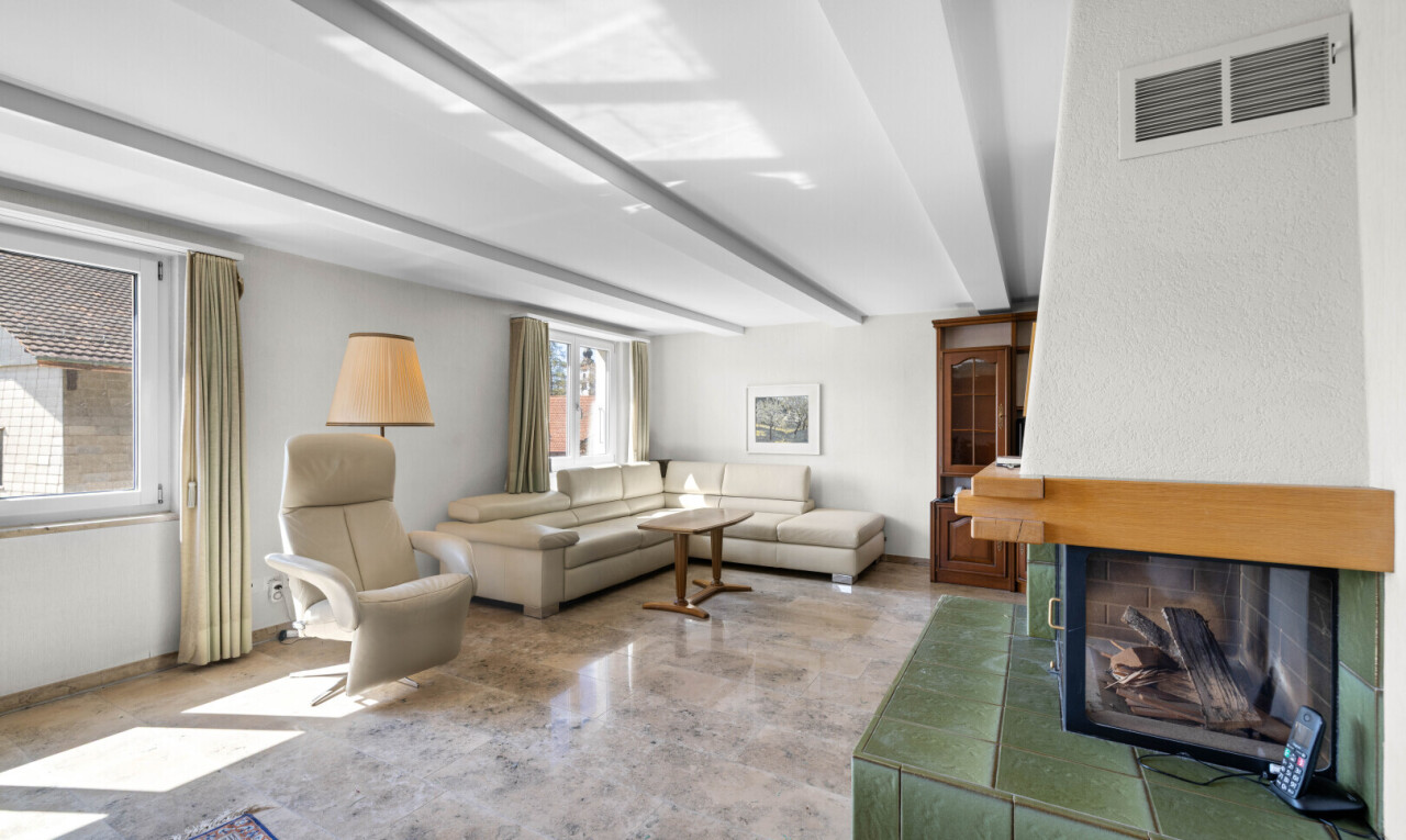 wohnzimmer mit beamed ceiling, balkendecke, kamin, inside property, und drywall