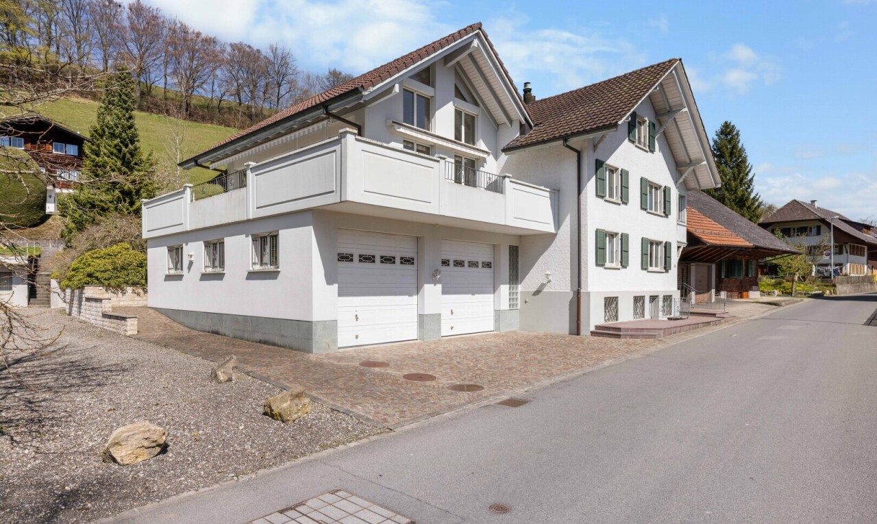 façade avec garage intégré, bardage en stuc, et day time