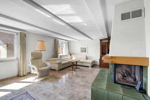 wohnzimmer mit beamed ceiling, balkendecke, kamin, inside property, und drywall
