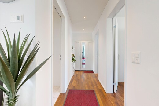 couloir avec cloison sèche, drywall, inside property, sol en finition bois, et wood finish floor