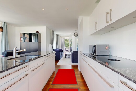cuisine avec white cabinets, armoires blanches, stone countertops, plans de travail en pierre, et évier