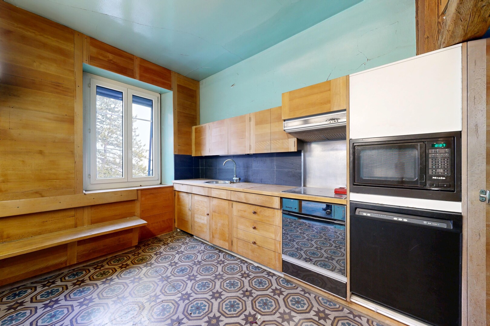 cuisine avec armoires marron clair, light brown cabinets, plans de travail, light countertops, et four